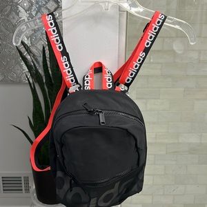 Adidas black canvas backpack with neon peach, black straps with adidas logo.